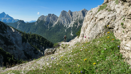 Tourist with equipment on a mountain trail in the Alps