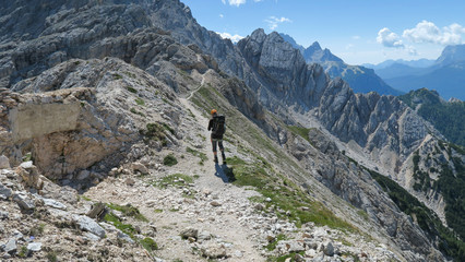 Fototapeta na wymiar Tourist with equipment on a mountain trail in the Alps