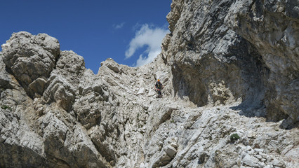 Fototapeta na wymiar Tourist with equipment on the via ferrata trail in the Dolomites