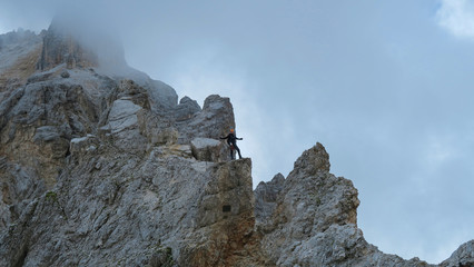 Tourist with equipment on the via ferrata trail in the alps