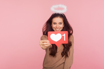 Social media Like button. Portrait of happy angelic young woman with halo over head holding...