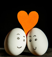two happy and loving eggs on a black background. Valentine's day