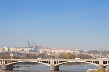 Obraz premium Panorama of the Old Town of Prague, Czech Republic, with a focus on Jiraskuv Most bridge and the Prague Castle (Hrad Praha) seen from the Vltava river. The castle is the main touristic landmark