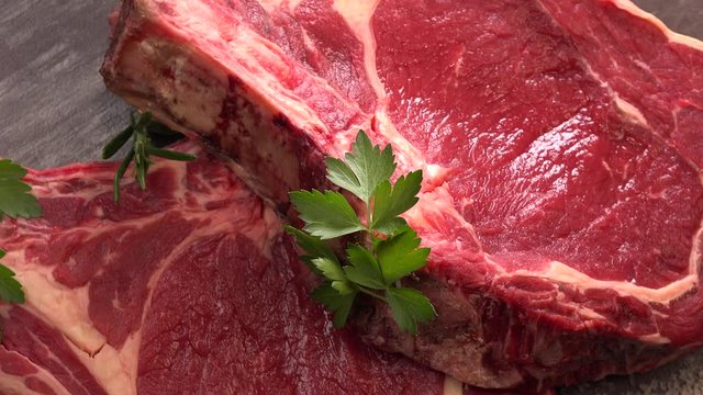 Raw T Bone steak on wooden board prepared to Grill on turntable