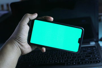 A man hold smartphone with green screen (Chroma key). Open conceptual for technology stuff.