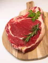 Raw T Bone steak on wooden board prepared to Grill 