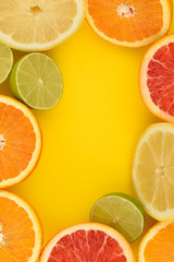 Citrus frame. Citrus Fruits mix flat lay including lemon, lime, grapefruit and orange on a yellow background. Copy space. Vitamins boom. Whole and sliced citrus fruit. Fruit background. Antioxidant .