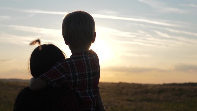 lifestyle happy family mom and son a sunset slow motion video concept . back view Mother girl and son boy playing on nature outdoors at the sunset time .Concept of friendly sunset family