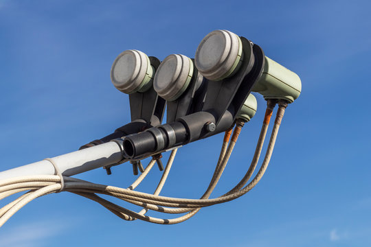 Three linear polarised LNB of a satellite dish closeup on blue sky background. Digital Video Broadcasting &ndash; Satellite.