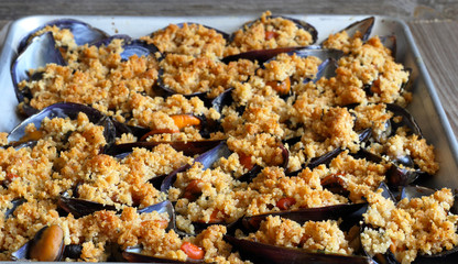 Vassoio contenete cozze gratinate cotte al forno. Deliziosi frutti di mare.