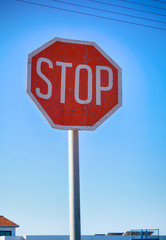Stop road sign against blue sky.
