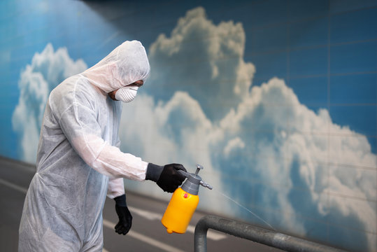 Ein Mann in einem Schutzanzug desinfiziert Flächen im öffentlichen Raum um die Ausbreitung des Coronavirus einzudämmen