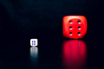 Big red dice next to a small white dice