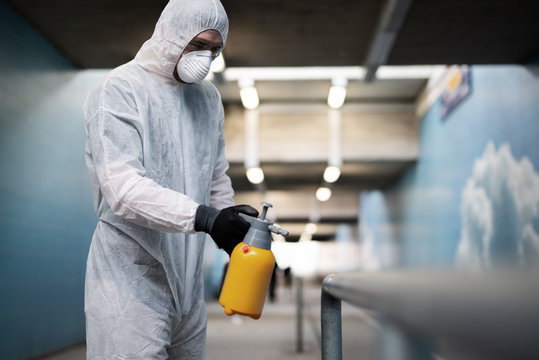 Ein Mann in einem Schutzanzug desinfiziert Flächen im öffentlichen Raum um die Ausbreitung des Coronavirus einzudämmen