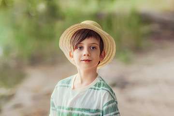 boy fisherman in a hat on the river