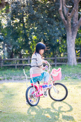 Obraz premium 春の公園で自転車を乗って遊んでいる可愛い子供
