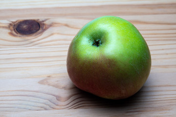 an Apple shot from the side on a wooden background