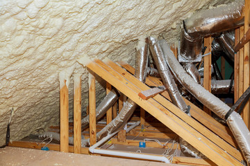 Insulation of attic with insulation material and pipe heating system a wooden beams of a roof structure