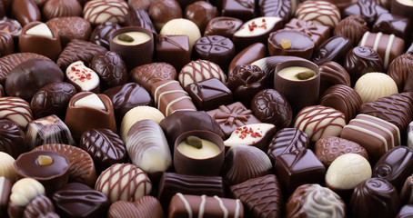 assorted chocolate candy with various fillings, sweet food background.