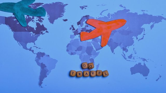 Stop motion of paper airplane moves around the world with 'Go travel' words.