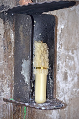 Church candle in a candlestick. Extinguished candle