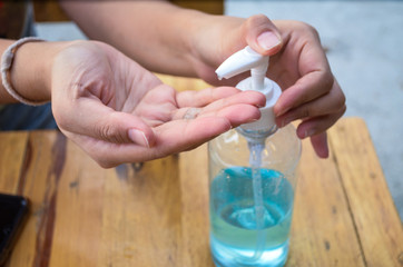 women washing hands with blue alcohol gel for protection corona virus(covit-19) and bacteria in restaurant.