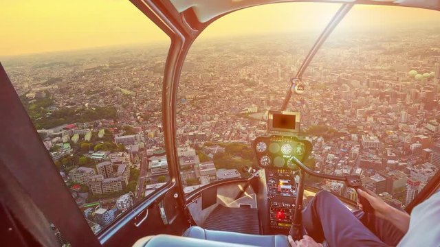 TIMELAPSE: Helicopter cockpit inside the cabin flying above panoramic twilight of Yokohama Skyline and Minato Mirai waterfront district at sunset.