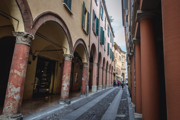 Narrow street with porticoes in historic part of Bologna, Italy © Fotokon