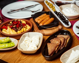 continental breakfast with cheese, sausages, toasts, olives, and roasted potatoes
