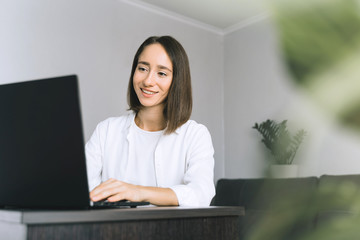 Happy young business woman or student with using laptop at the home office. Frelance work from home in quarantine concept.