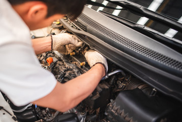 Auto technicians are checking car injection systems using diagnostic and repair tools in the engine...