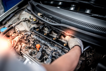 Auto technicians are checking car injection systems using diagnostic and repair tools in the engine...