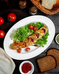 fried chicken wrap stuffed with vegetables garnished with lettuce and tomato
