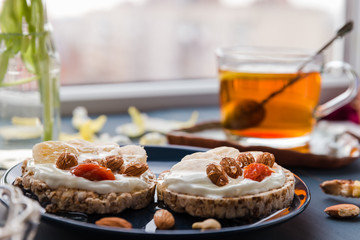 simple breakfast decoration at home. delicious toast on a blue plate. hand holding toast. breakfast at home. cup of tea with lemon and banana and almond toast. breakfast at home. breakfast idea