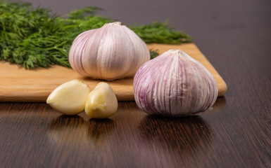 Garlic and dill are on the cutting Board.