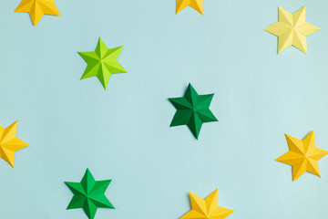Obraz premium Colored paper stars over blue background