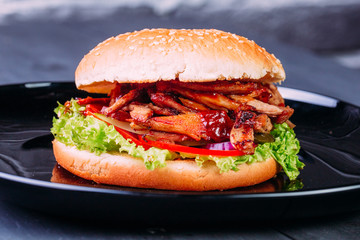 Fresh burger over wooden table and dark background. Front view