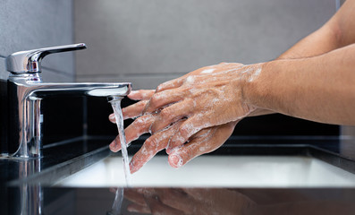 Man is washing his hands in a sink sanitizing the colona virus for sanitation and reducing the spread of COVID-19 spreading throughout the world, Hygiene ,Sanitation concept.