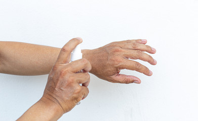 Fototapeta premium Man uses a spray of alcohol to get rid of bacteria and viruses, Inhibition and prevention of Covid-19 virus infection using 70 percent alcohol, protect virus concept.