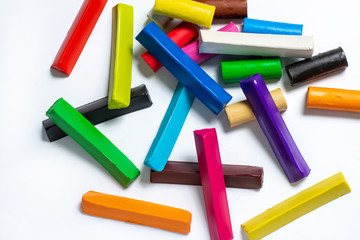 multi-colored plasticine cubes lie a bunch on a white background. isolate. children's creativity