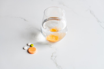 Multivitamin tablets and effervescent tablet with a glass of water