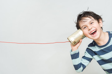 Little boy holding a can with a cord