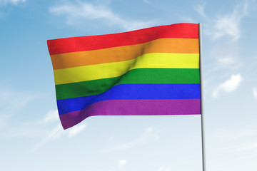 LGBT flag waving in the wind. Sky in background.