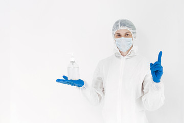 A man in a protective suit holds an antibacterial antiseptic gel for hand disinfection. Health care prevention during an outbreak of the flu virus and a coronavirus epidemic