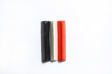 Three multi-colored plasticine bars on a white background. material for children's creativity. isolate.