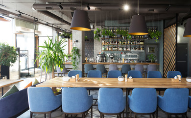 View on bar with wooden counter and chairs in Modern cafe