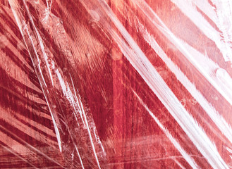 Plastic films on a red wooden board.