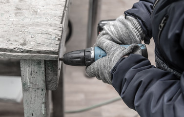 Worker fastens wooden planks.