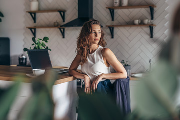 Obraz na płótnie Canvas Young female entrepreneur sits at kitchen table