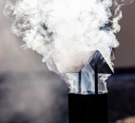 White smoke comes from a metal pipe.